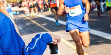 Ein Mann bekommt die optimale Verpflegung beim Marathon