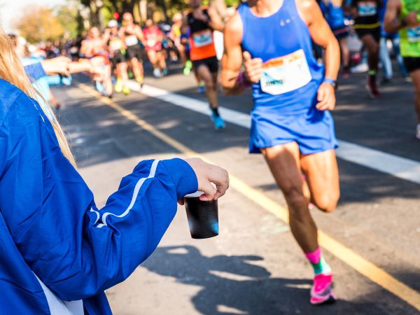 Ein Mann bekommt die optimale Verpflegung beim Marathon